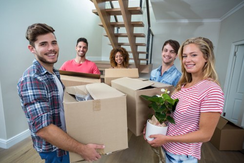 Moving crew handling boxes and furniture in a Notting Hill flat