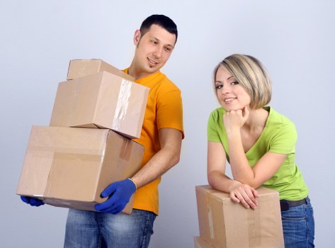 Removalists handling boxes and furniture in a Notting Hill apartment building